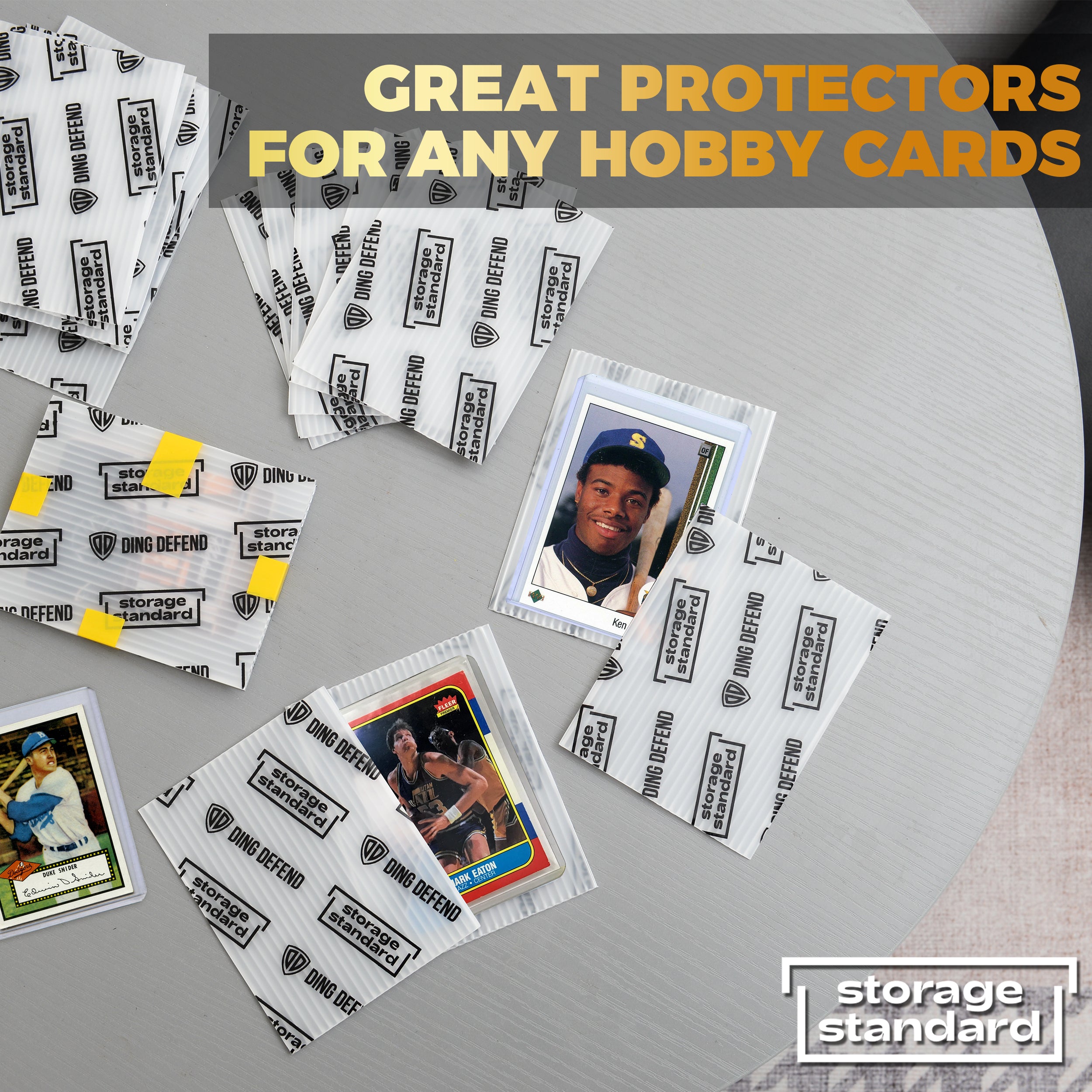 Ding Defend card shipping sleeves protecting baseball cards and hobby collectibles on tabletop